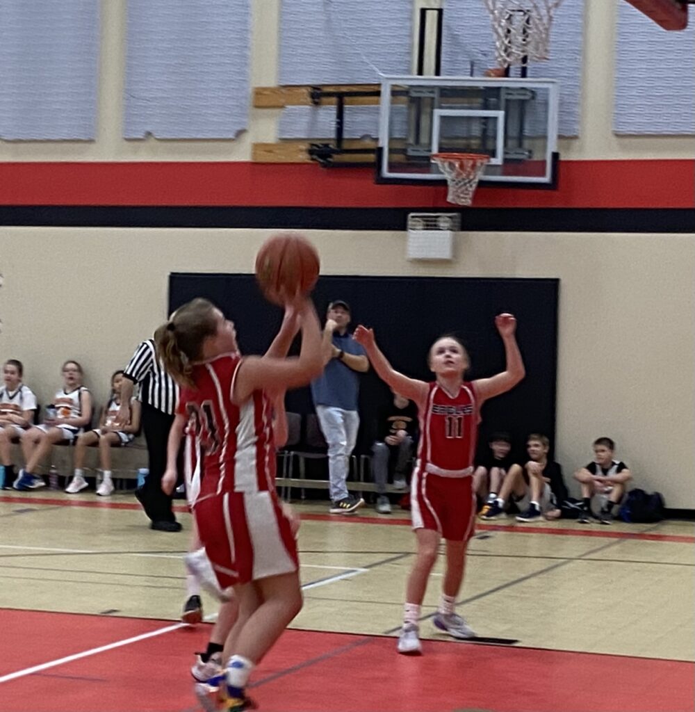Middle school girls basketball team playing a game against another team.